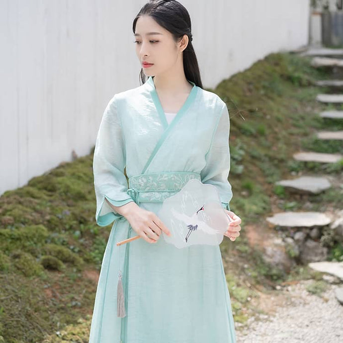 A woman with a green modern hanfu dress with waistband
